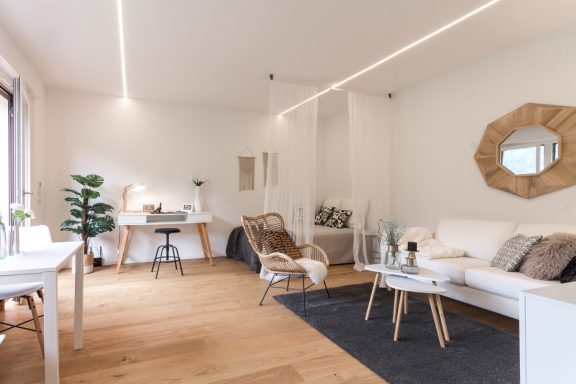 Heller Wohnbereich mit Sofa, Essplatz und stimmigem Beleuchtungskonzept