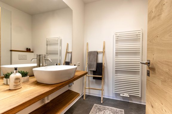 Modernes Badezimmer mit Holzwaschtisch und stilvoller Ausstattung