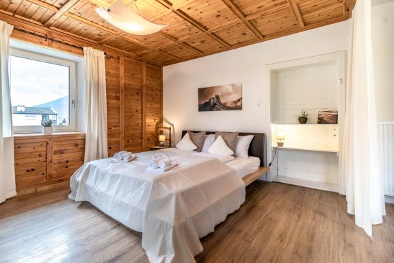 Helles Schlafzimmer mit großem Bett und warmen Materialien