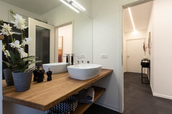 Rundes Waschbecken auf Holzplatte in modernem Bad